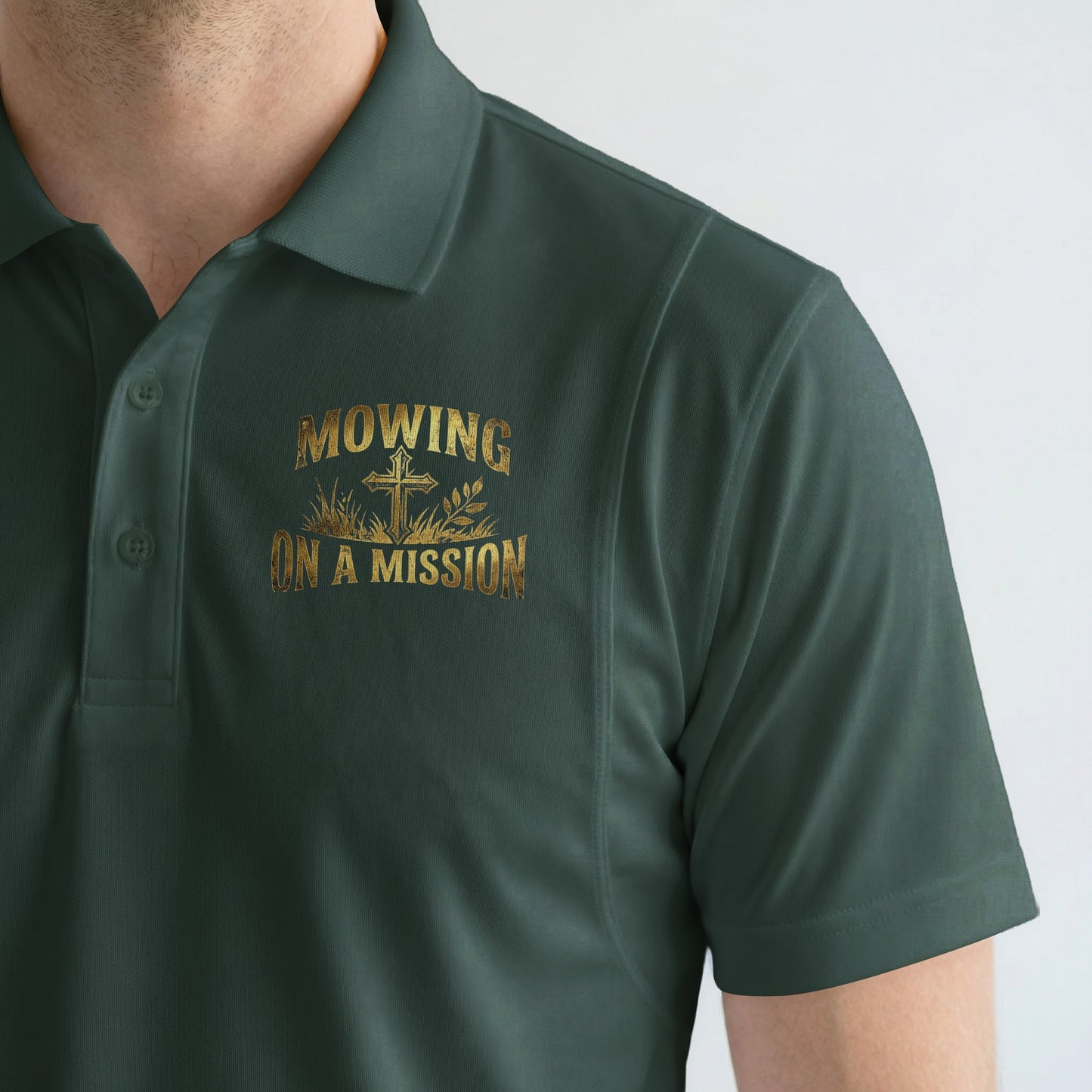 Green polo shirt with gold text and design that reads "MOWING ON A MISSION".