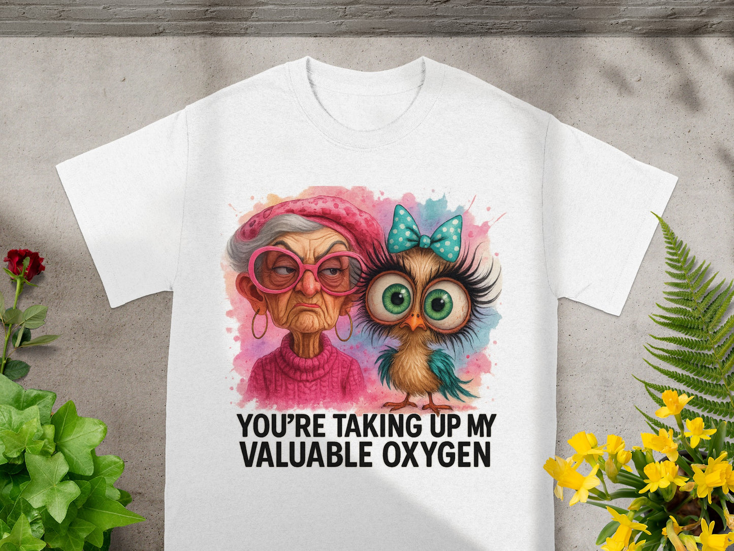 White t-shirt with watercolor graphic of a grumpy woman and a bird, text reads "YOU'RE TAKING UP MY VALUABLE OXYGEN".