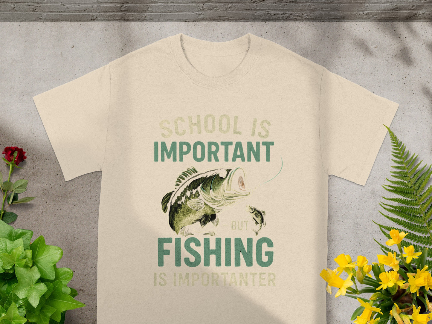 Cream t-shirt with graphic of a bass fish and the text "School is important but Fishing is importanter".