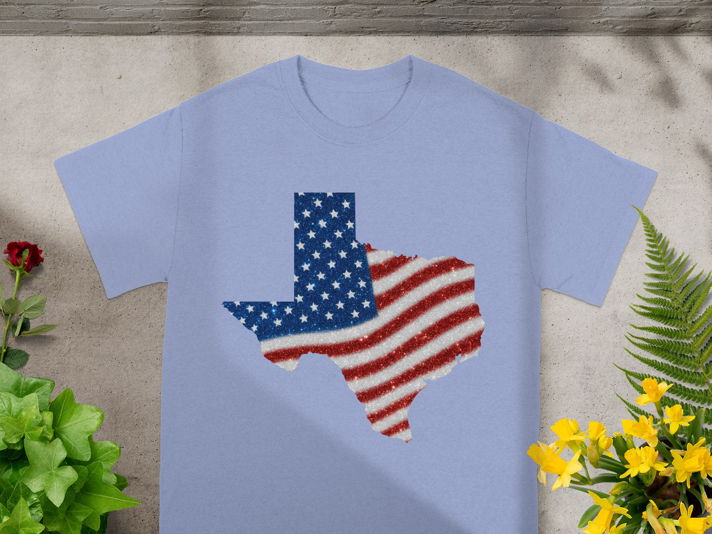 Light blue t-shirt with Texas shape in American flag glitter design.