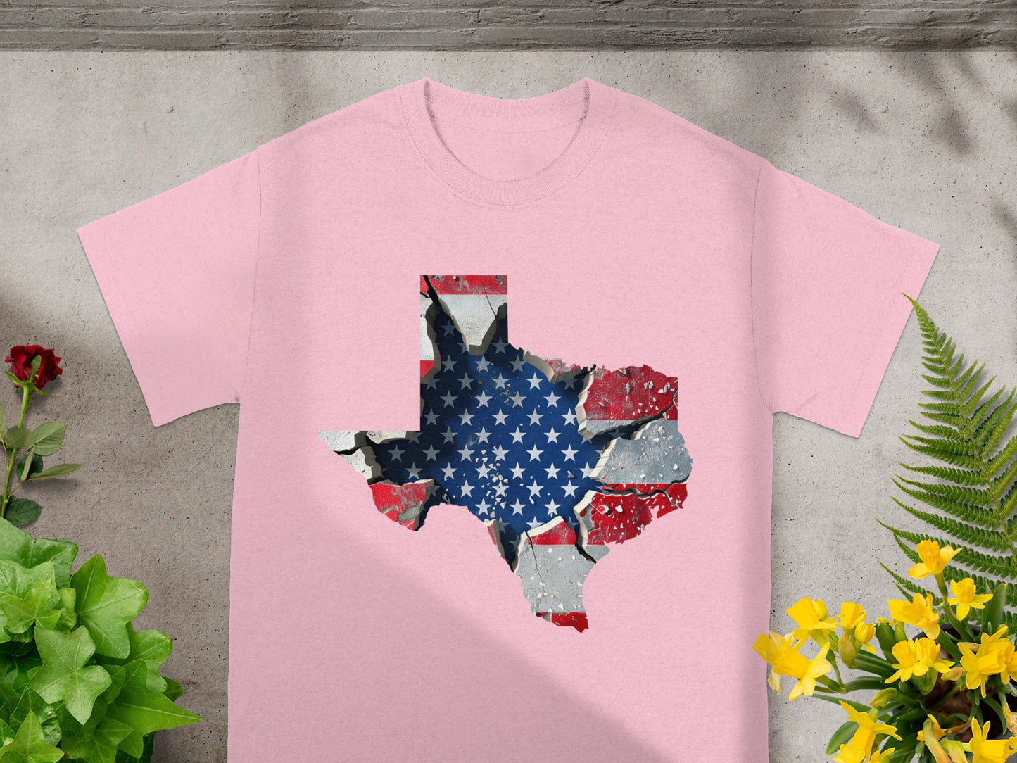 Pink t-shirt with a Texas shape filled with a cracked American flag design.