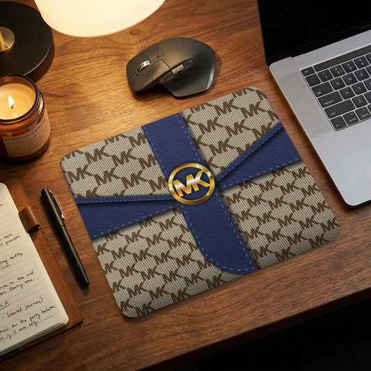 Michael Kors monogram mousepad with gold logo on navy ribbon detail.