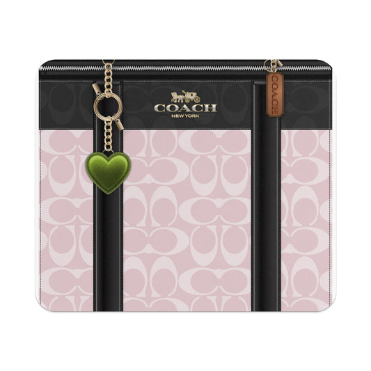 Coach pattern pink wallet with green heart charm and gold chain.