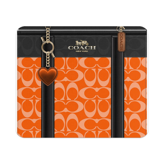 Coach orange monogram pattern with black trim and heart charm.