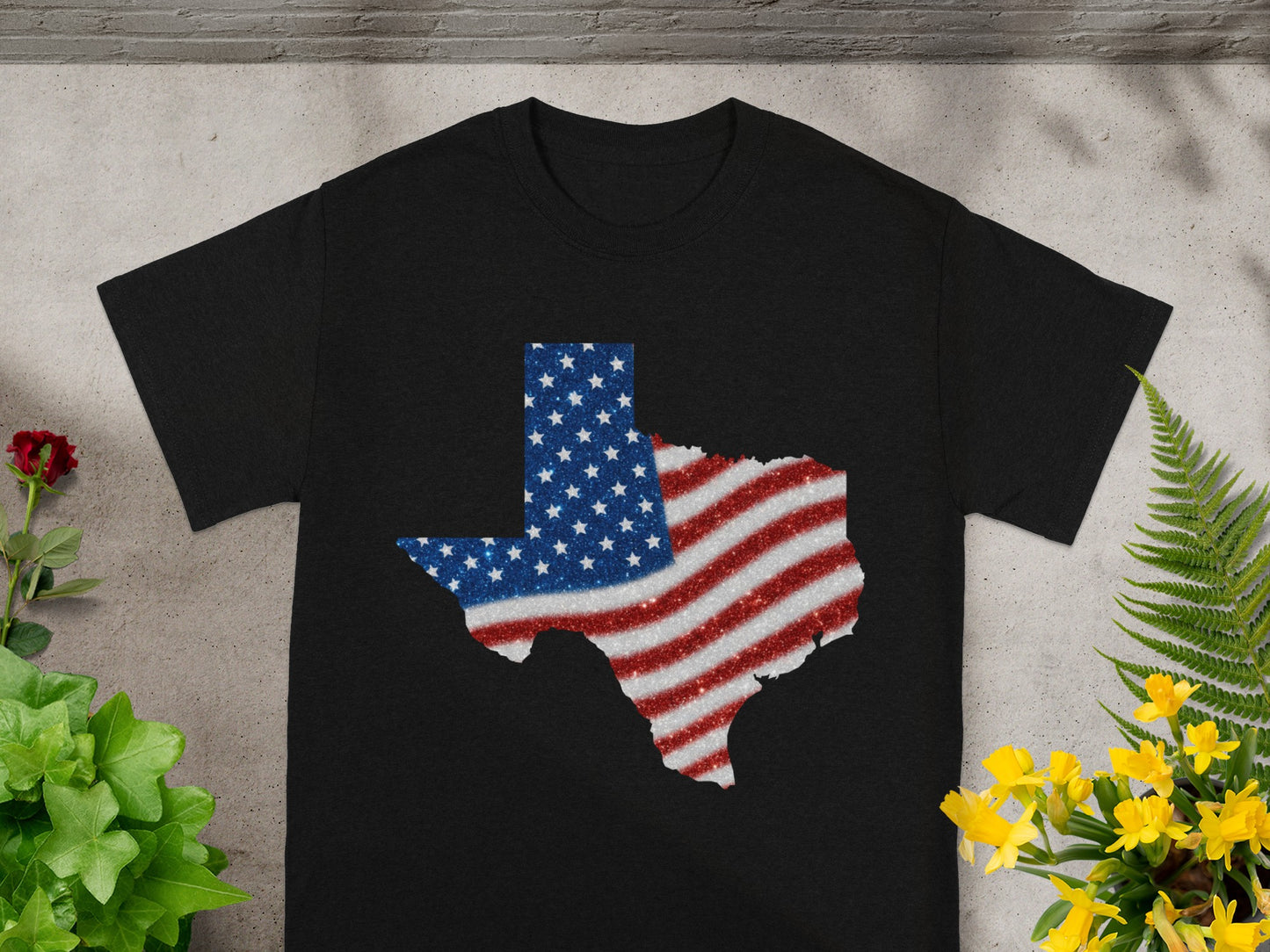 Black t-shirt with Texas map outline filled with American flag glitter design.