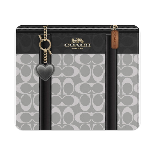 Coach signature pattern case with heart charm and gold hardware.
