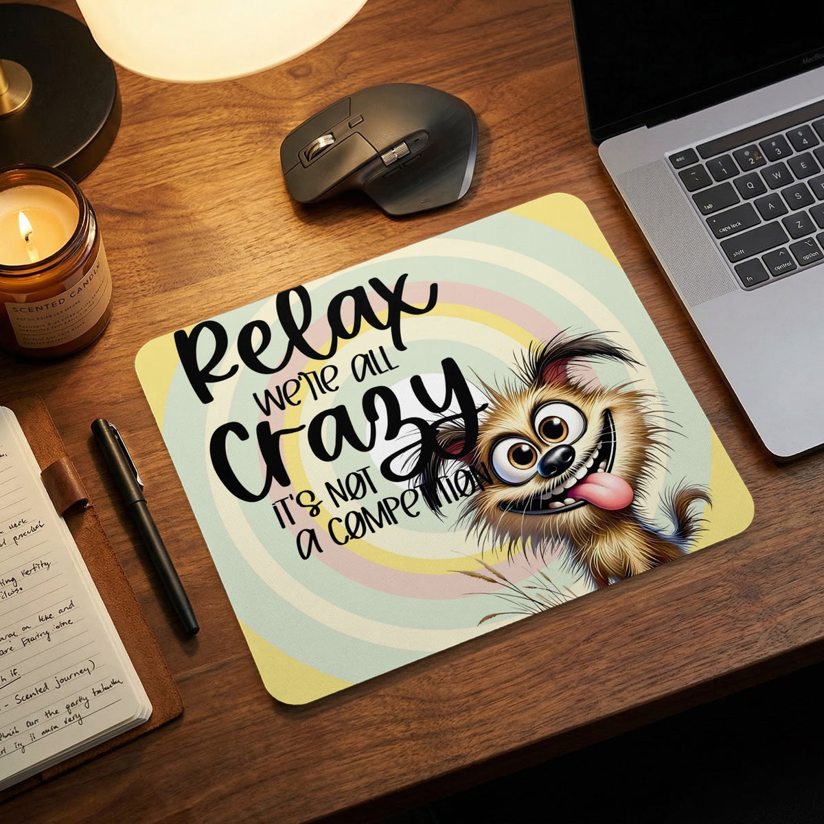 A rectangular mousepad featuring an illustrated cartoon dog and the text Relax we are all crazy, it is not a competition on a desk.