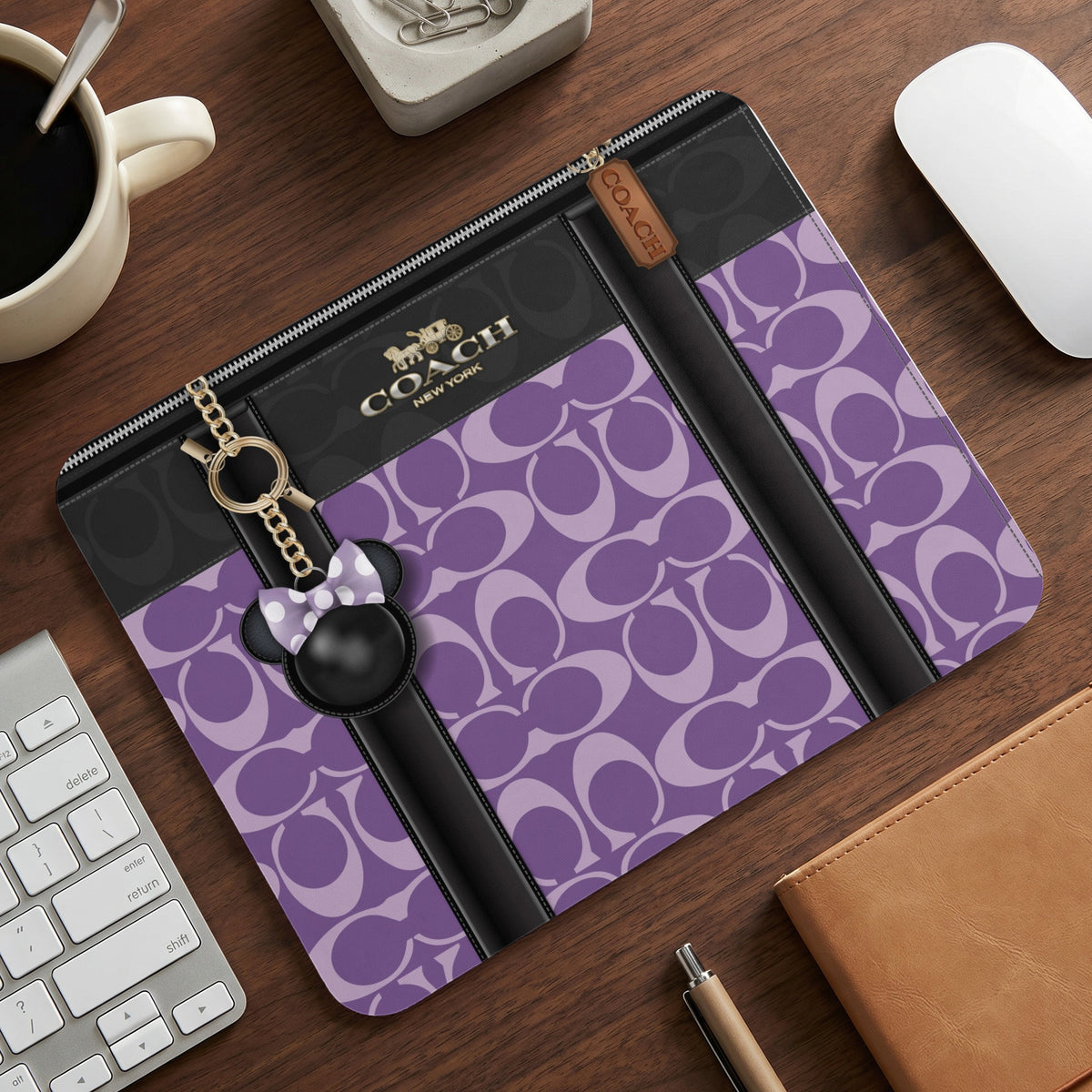 Coach branded pouch with purple C pattern and Mickey Mouse charm.