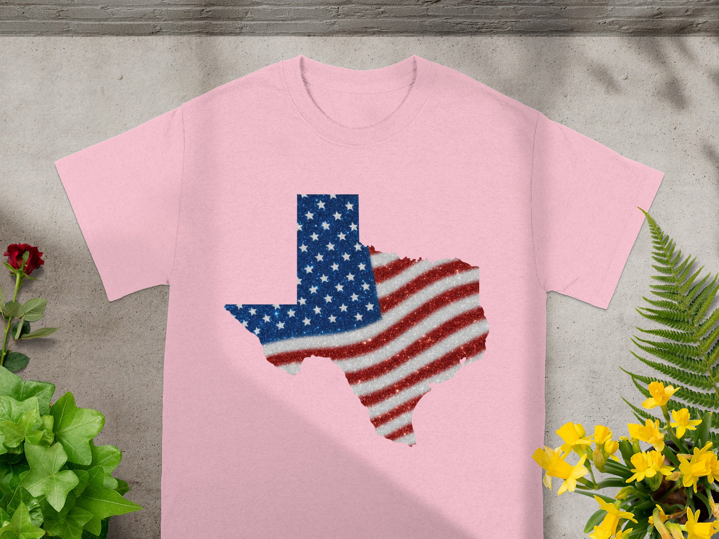 Pink t-shirt with a glitter Texas flag graphic.