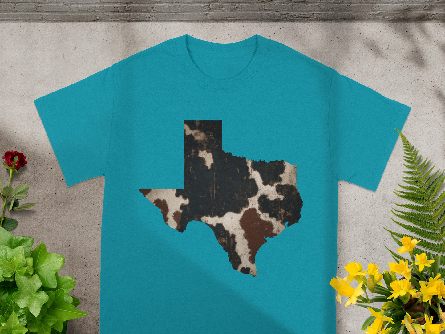 Teal t-shirt featuring a cowhide print Texas state outline.