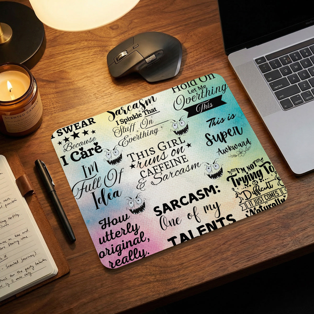 A colorful, patterned mousepad featuring humorous quotes and cartoon monster faces on a wooden desk.