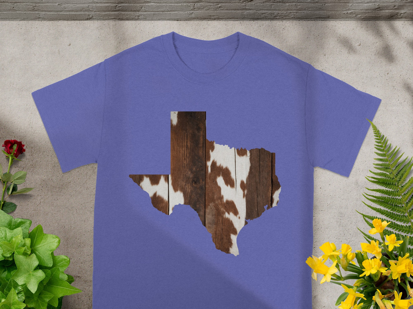 Purple t-shirt with Texas shape graphic featuring wood and cowhide pattern.