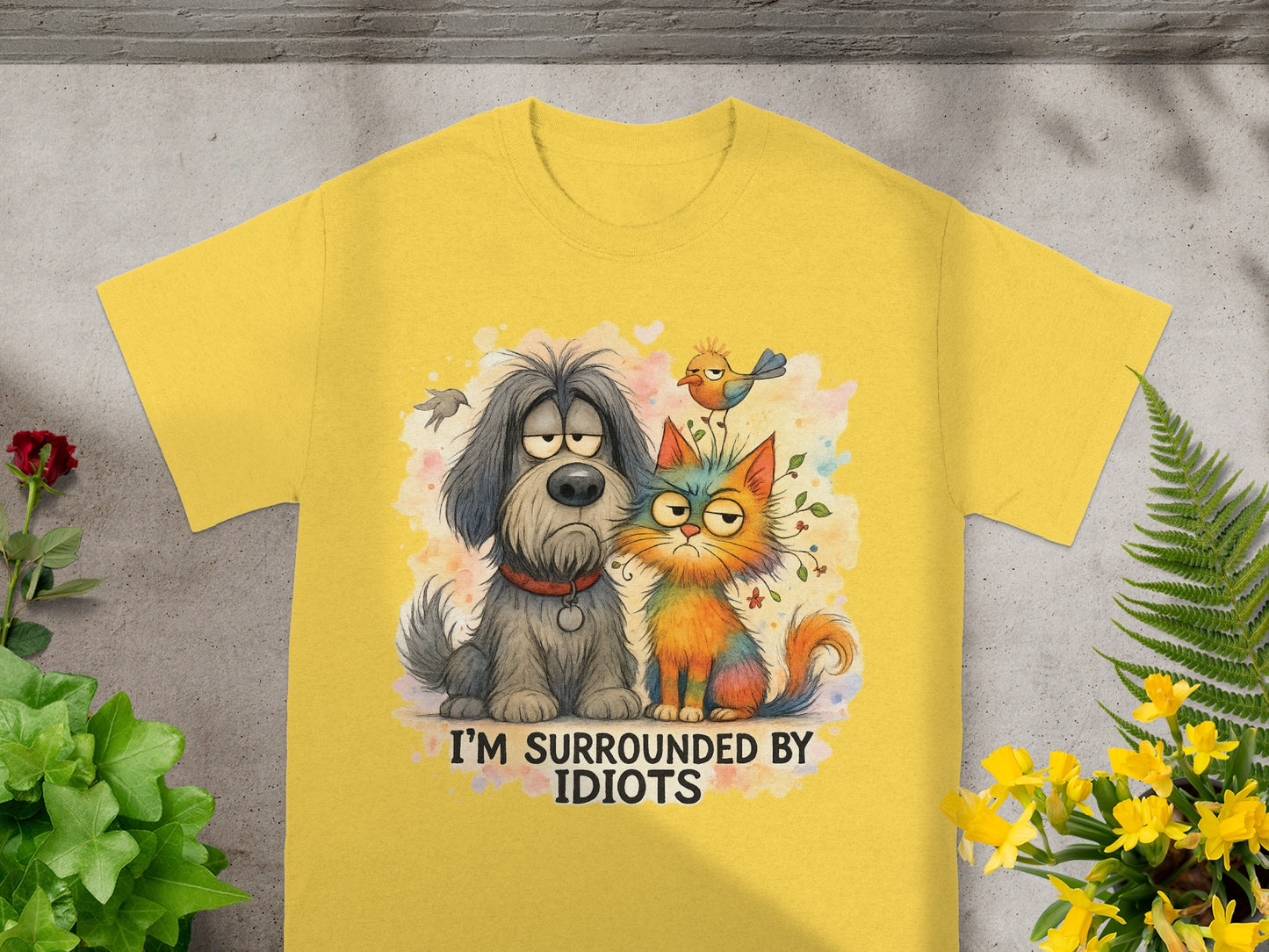 Yellow t-shirt with cartoon dog, cat, and bird, text "I'M SURROUNDED BY IDIOTS".