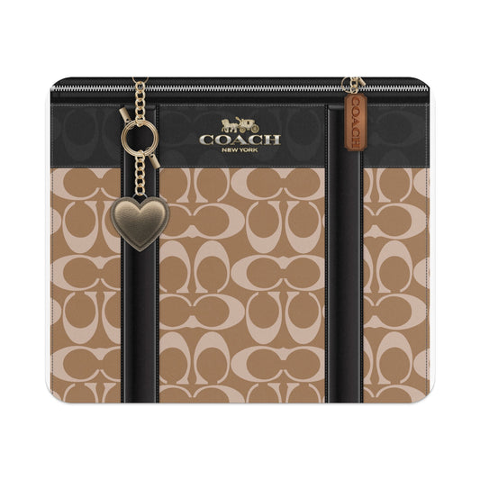 Coach signature canvas case with gold heart charm and brown leather tag.