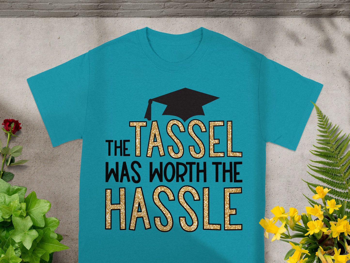 Teal t-shirt with "The Tassel Was Worth the Hassle" and graduation cap graphic.