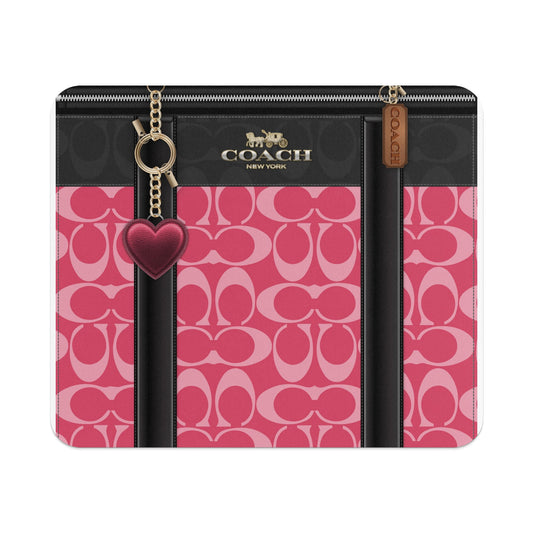 Coach New York wallet with pink C-pattern, black accents, and heart charm.