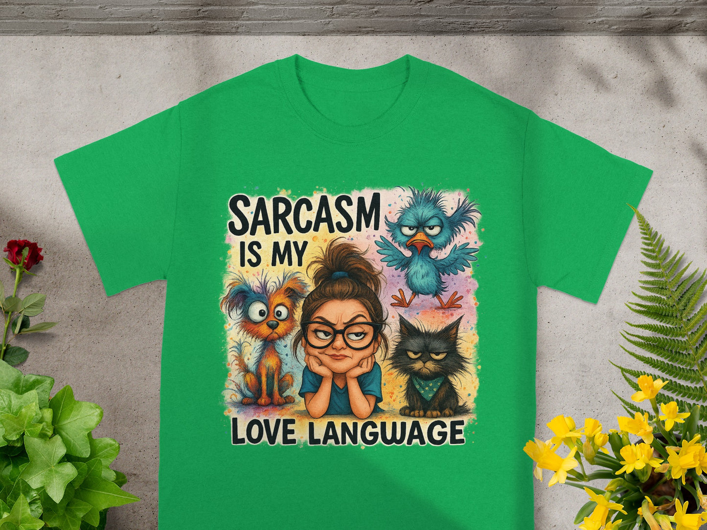 Green t-shirt with a woman, dog, cat, and bird illustration and "Sarcasm is my love language" text.