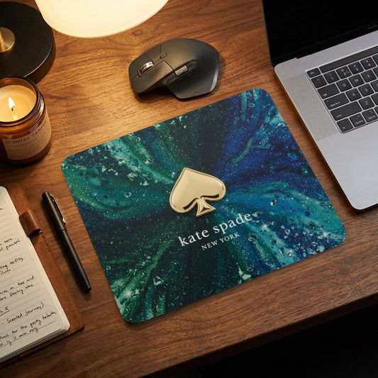 Kate Spade New York mousepad with gold spade logo on marble design.