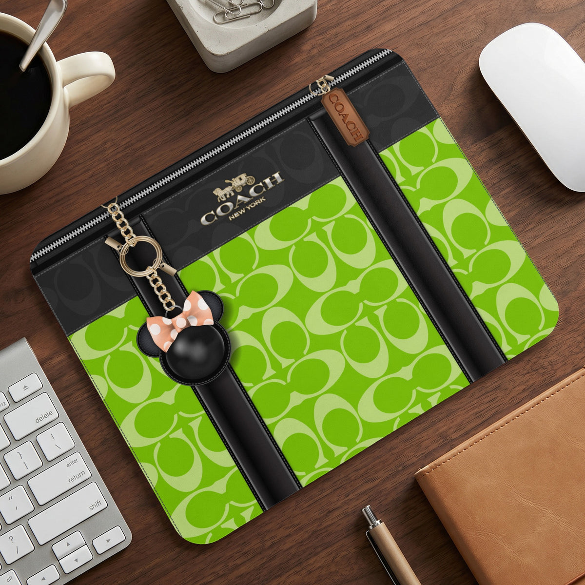 Coach clutch with green monogram pattern and Mickey Mouse charm.