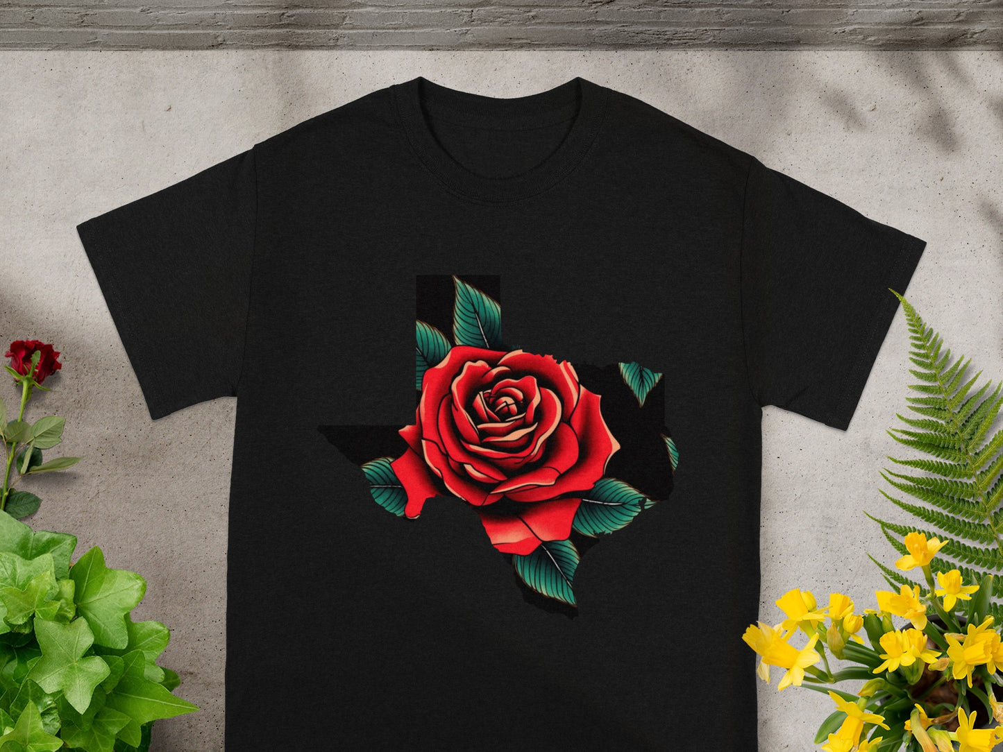 Black t-shirt with a red rose graphic overlaying the shape of Texas.