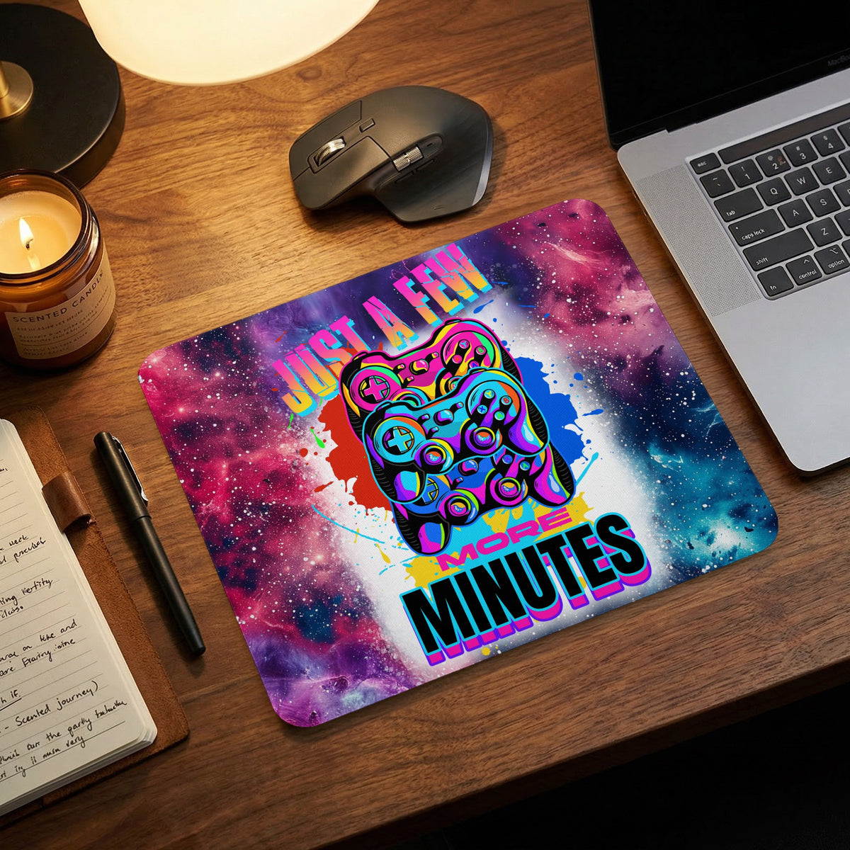 Mousepad with a cosmic galaxy print and two neon game controllers, featuring the text Just A Few More Minutes.