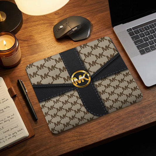 Michael Kors patterned mousepad with gold logo on desk.