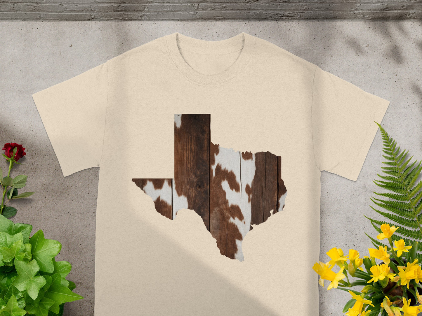 Cream t-shirt with Texas map graphic featuring wood and cowhide patterns.