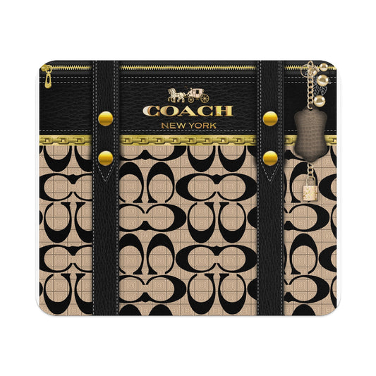 Coach New York patterned case with gold chain, leather straps, and charm.