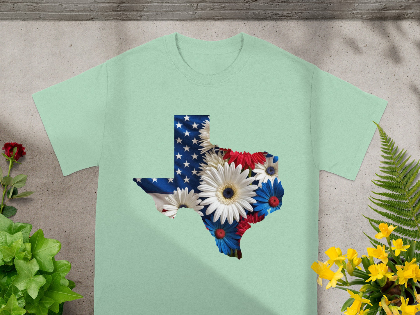 Light green t-shirt with Texas shape filled with American flag and patriotic flowers.