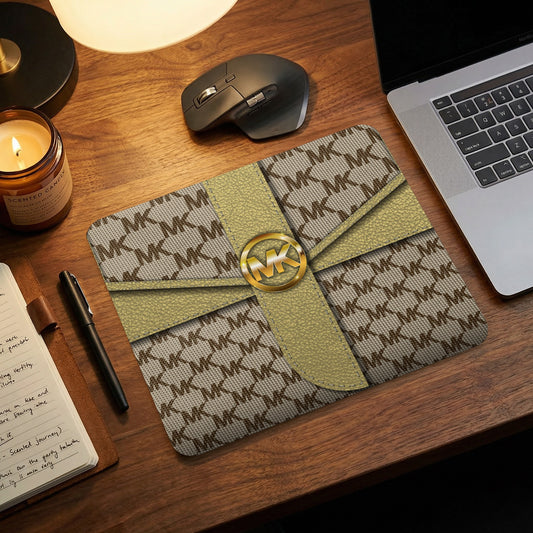 Michael Kors logo on a patterned mousepad with gold ribbon detail.