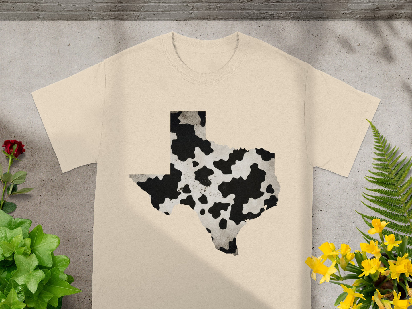 Cream t-shirt with a cow print Texas outline graphic.