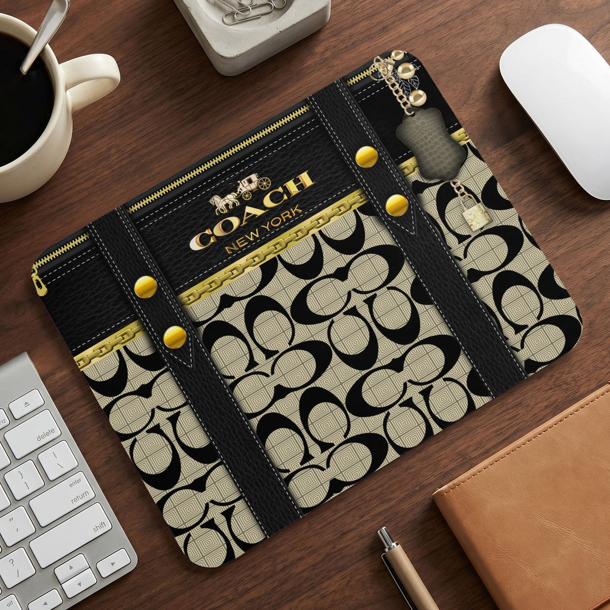 Coach New York print mousepad with gold zipper accents and keychain details.