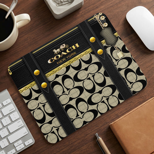 Coach New York print mousepad with gold zipper accents and keychain details.