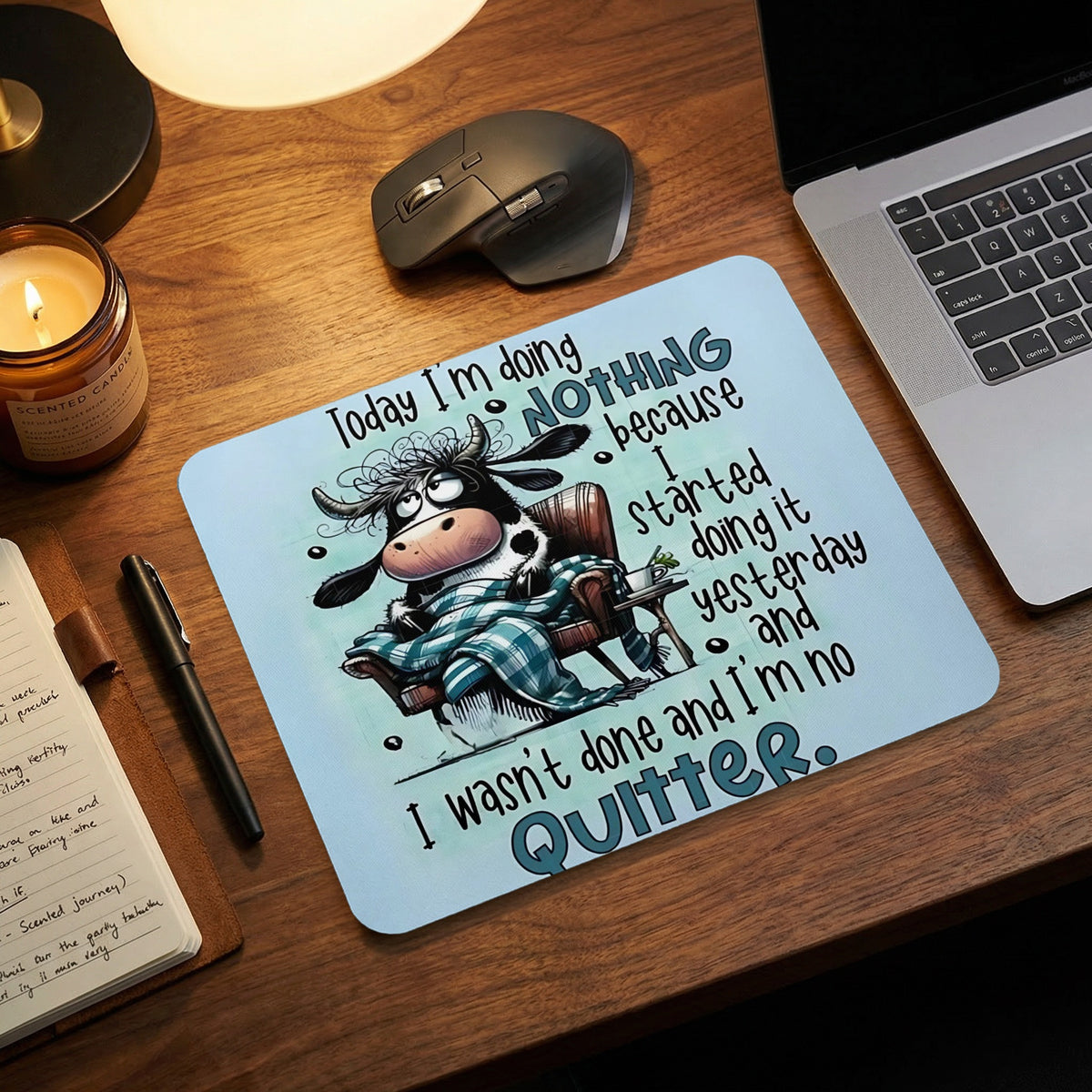 Light blue mousepad with a cartoon cow wrapped in a blanket, accompanied by humorous text.