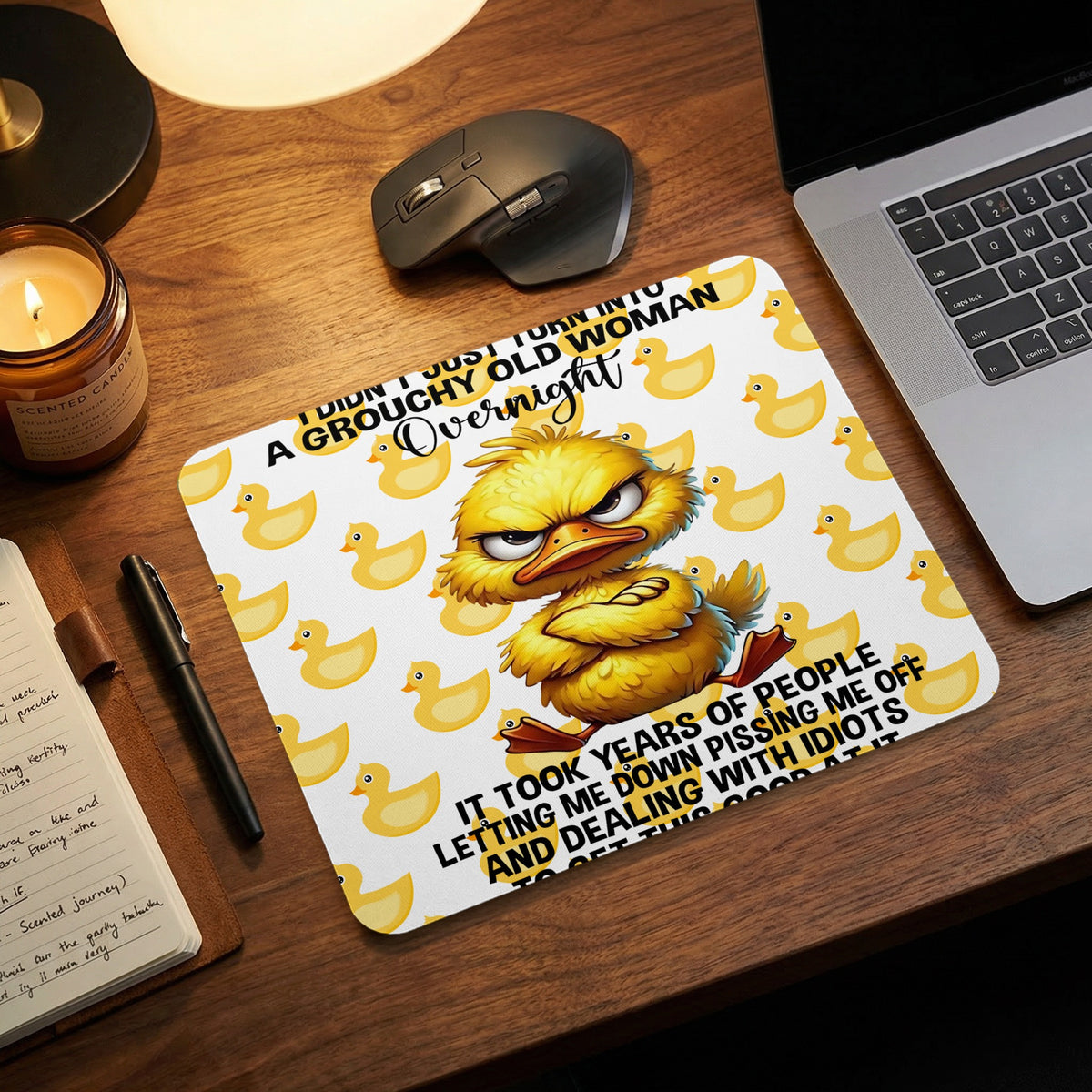 A mousepad featuring a grumpy yellow duck with text on a wooden desk.