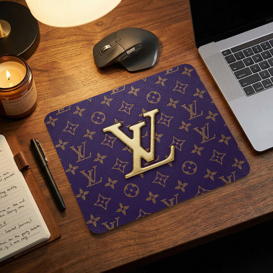 Gold LV logo on a purple monogram mousepad next to a laptop.