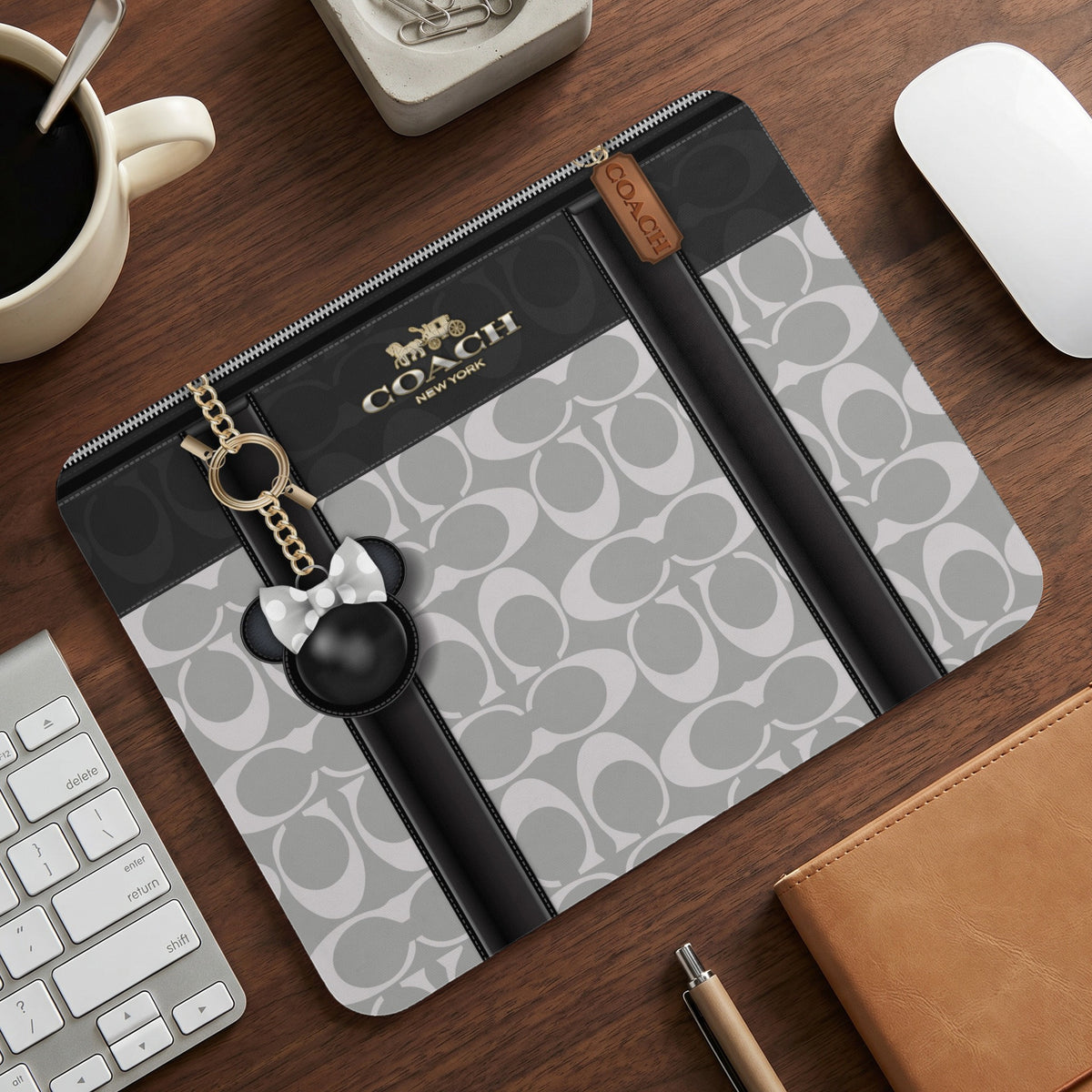 Coach mousepad with signature print, featuring a metal zipper, charm, and Disney character.