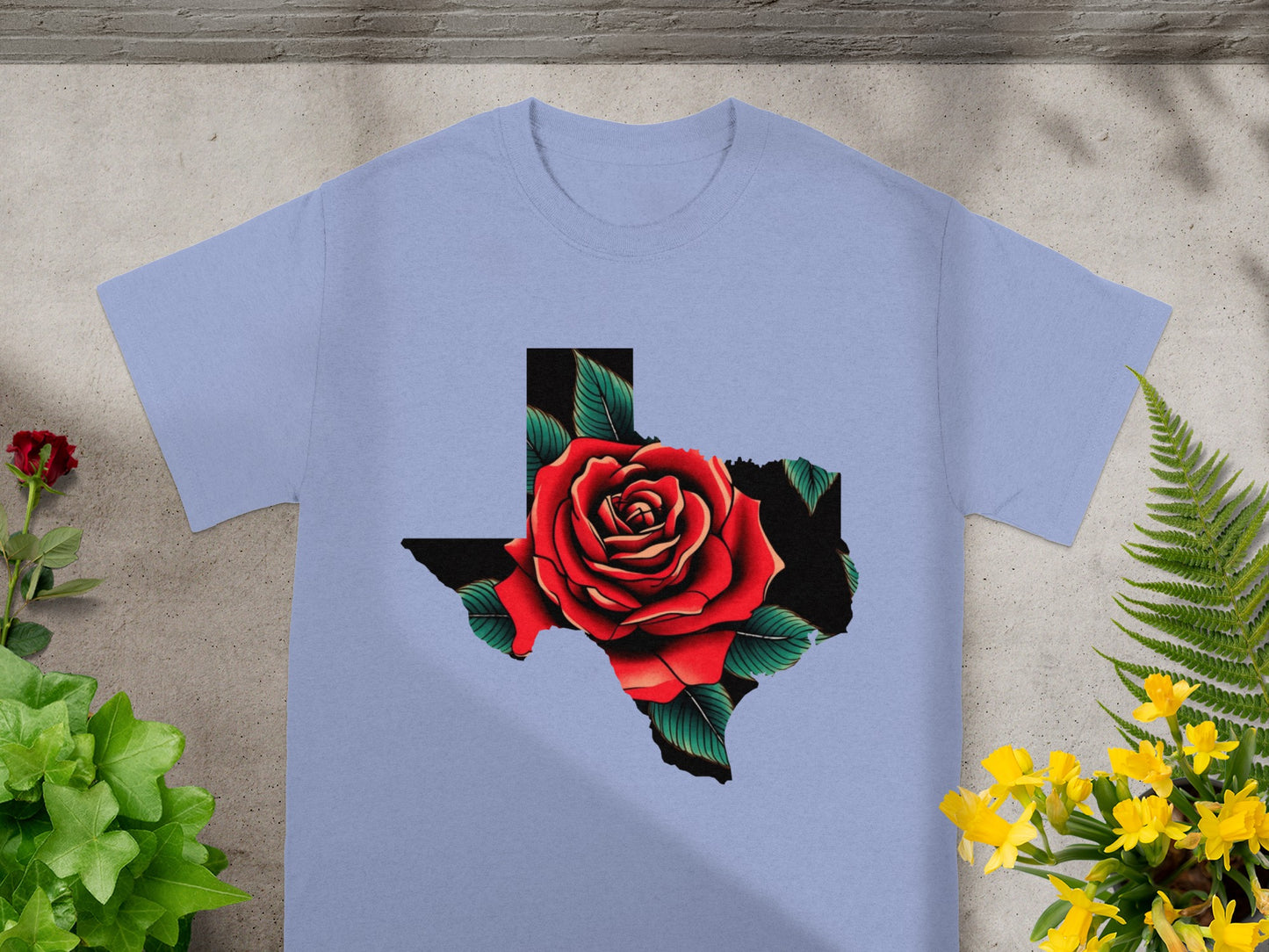 Light blue t-shirt with a red rose inside the outline of Texas.