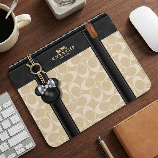 Coach notebook with signature pattern and Mickey Mouse charm.