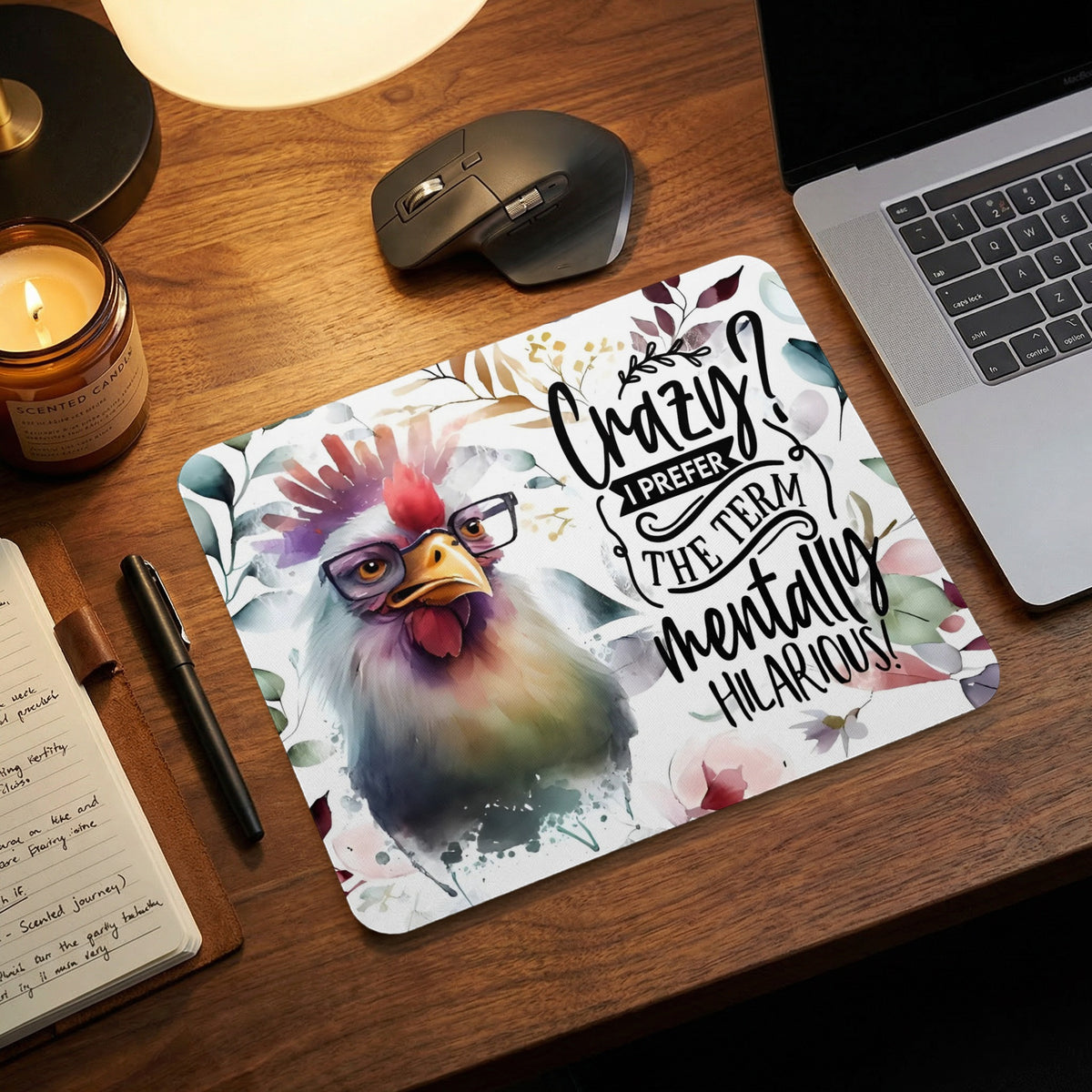 A colorful watercolor mouse pad featuring a rooster in glasses and funny typography on a desk.