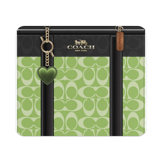 Coach green monogram pattern wallet with heart charm and leather tag.