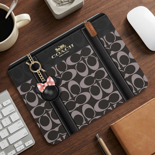 Coach signature print pouch with Mickey Mouse charm and gold hardware.