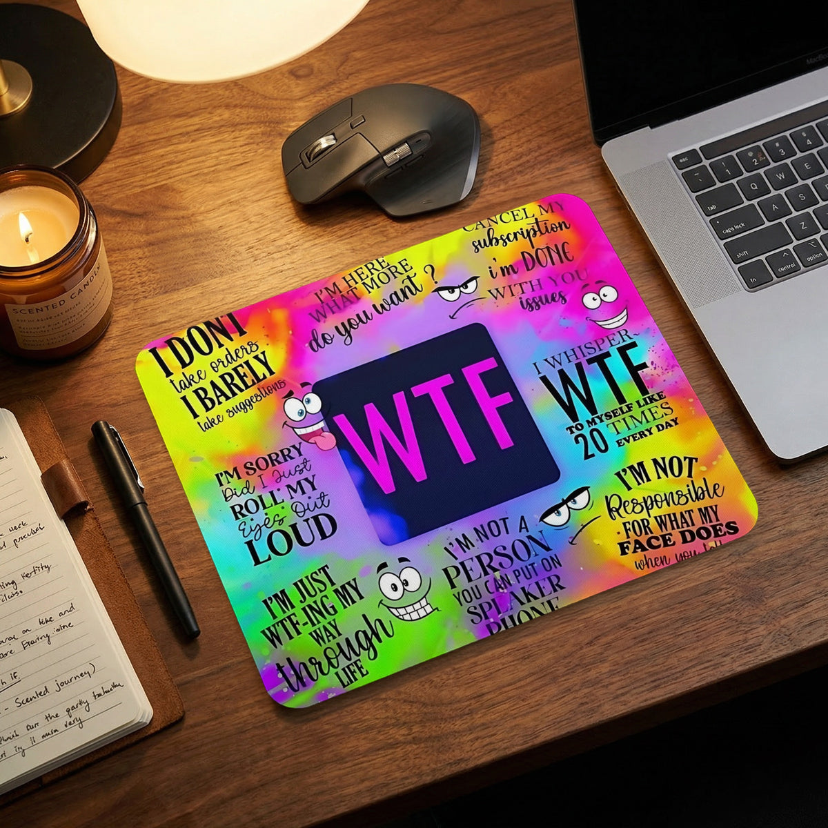 A brightly colored mousepad featuring sarcastic text and cartoon faces sits on a wooden desk.