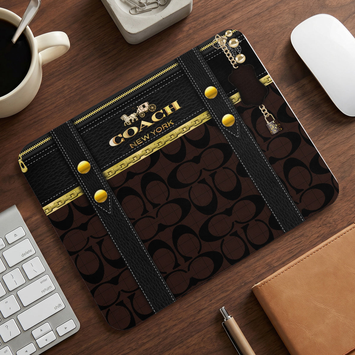 Coach New York mousepad with signature logo pattern and gold hardware details.