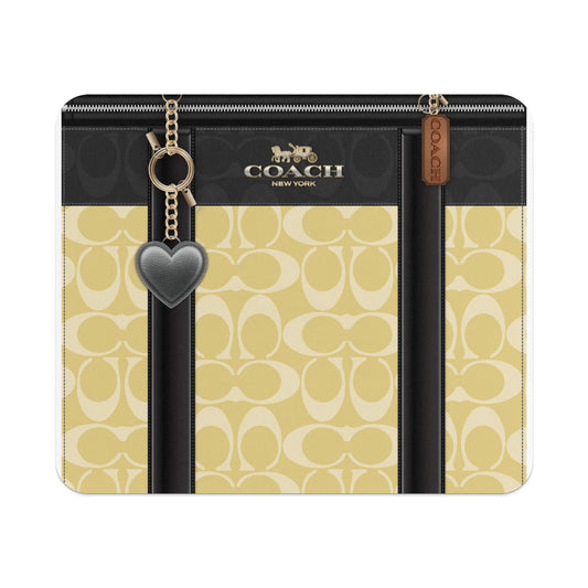 Coach New York bag with signature print, black trim, heart charm, and zipper.