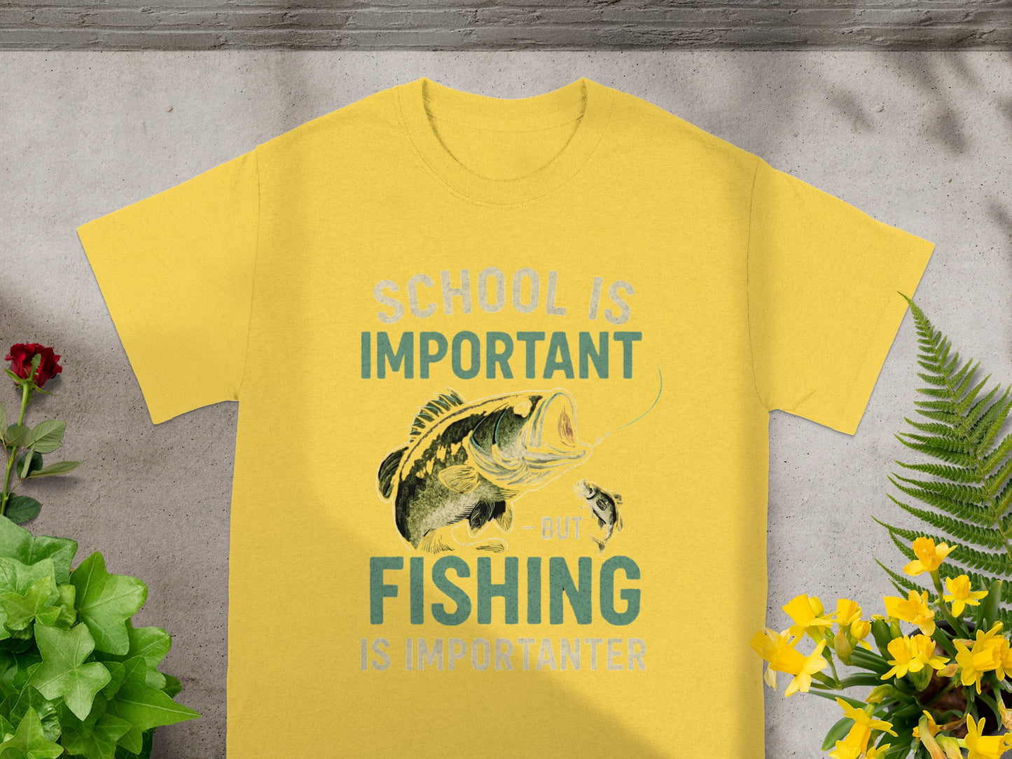 Yellow t-shirt with a graphic of a bass jumping to catch a smaller fish, text reads "School is Important, But Fishing is Importanter."