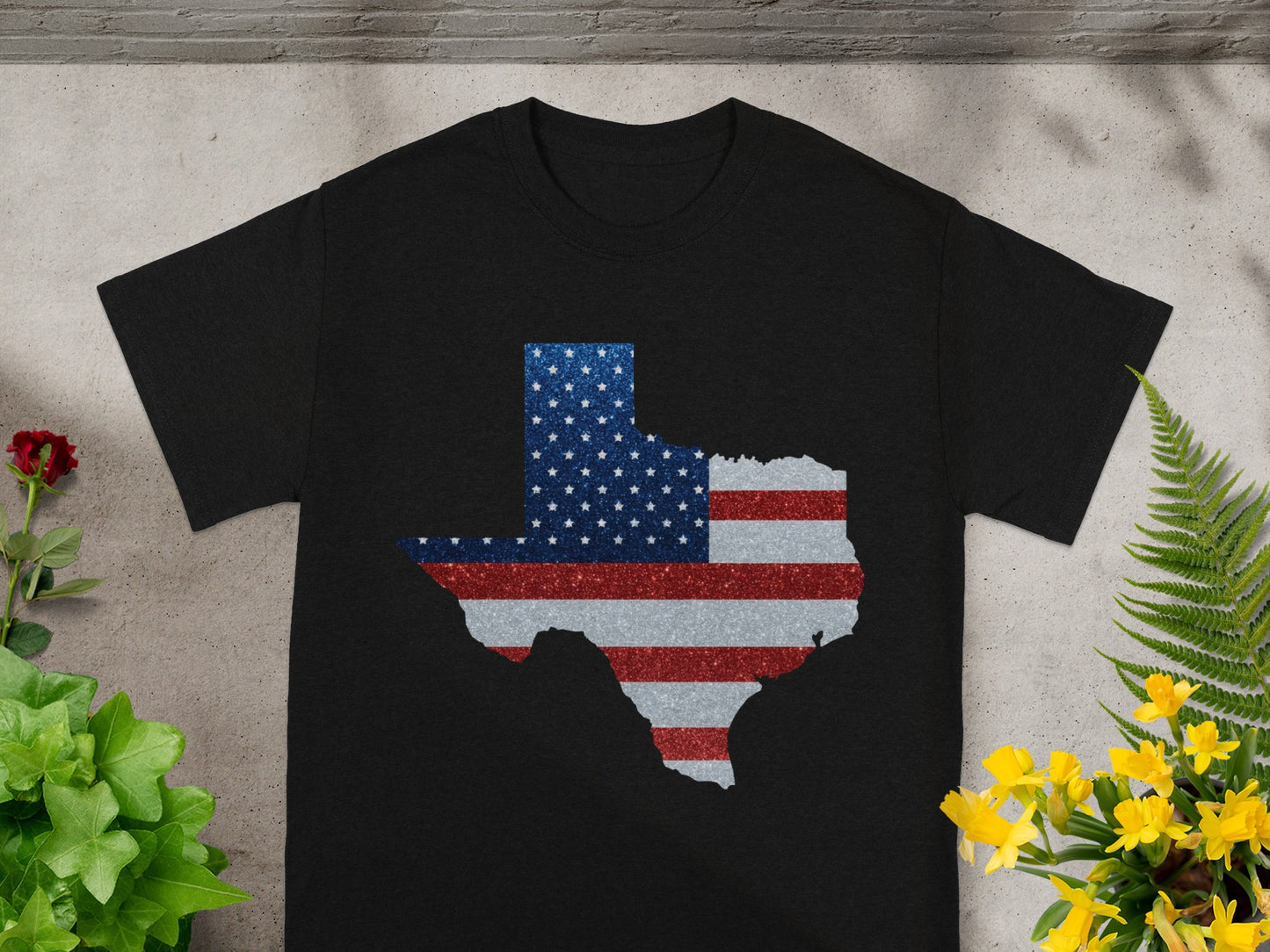 Black t-shirt with a glittery American flag design in the shape of Texas.