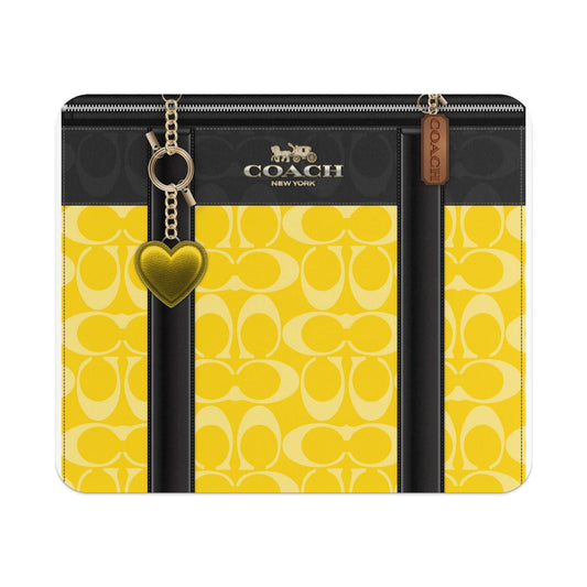 Coach yellow and black C-pattern wallet with heart charm and leather tag.