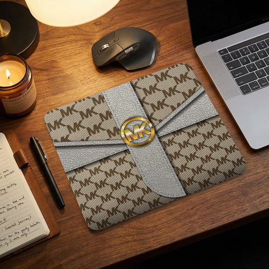 Michael Kors monogram mousepad with grey ribbon detail and gold logo.