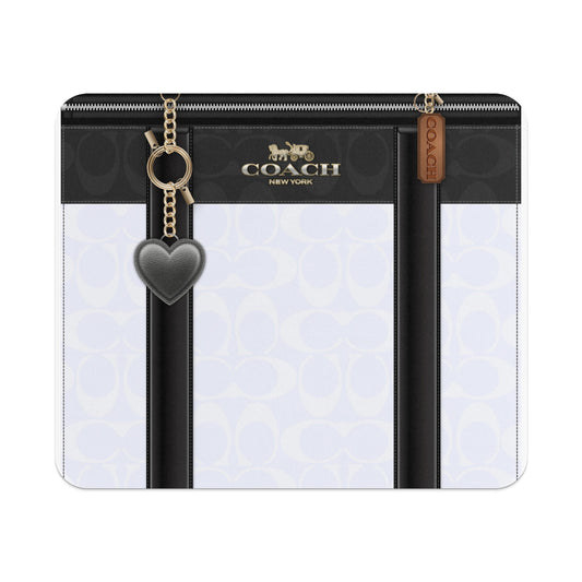 Coach black and white signature print pouch with heart charm and gold hardware.